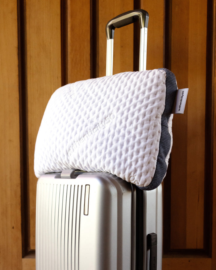A50 Travel Pillow propped on the top of a suitcase.