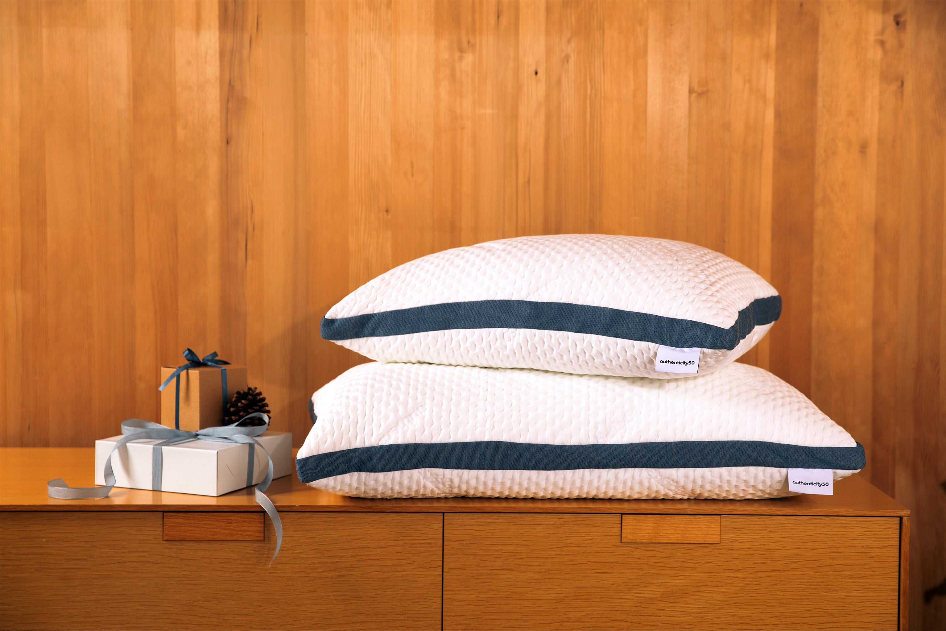 Stack of Custom Comfort Pillows sitting on a desk next to a stack of wrapped presents.