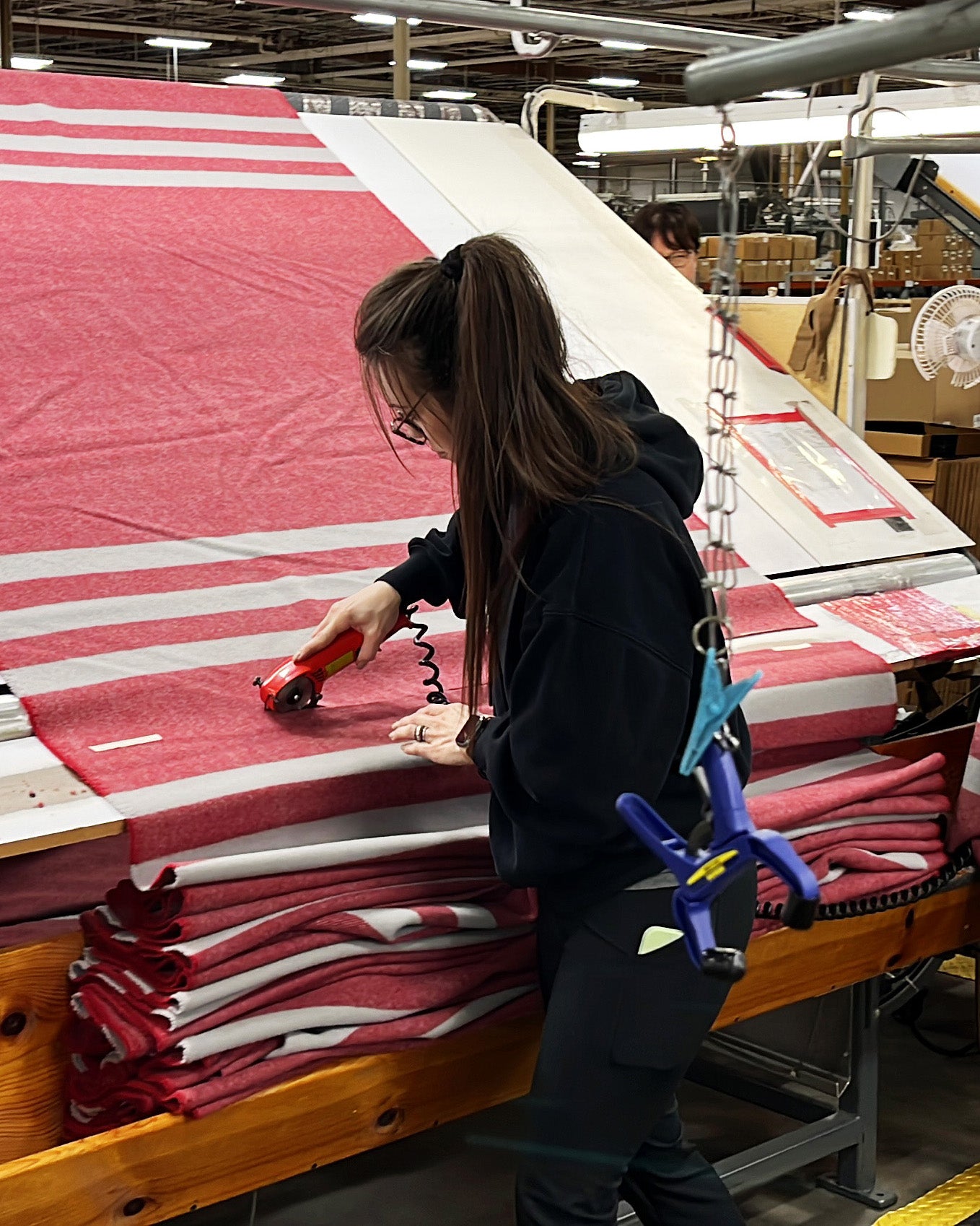 Worker cutting the wool fabric used to make our Northwest Wool Throws.