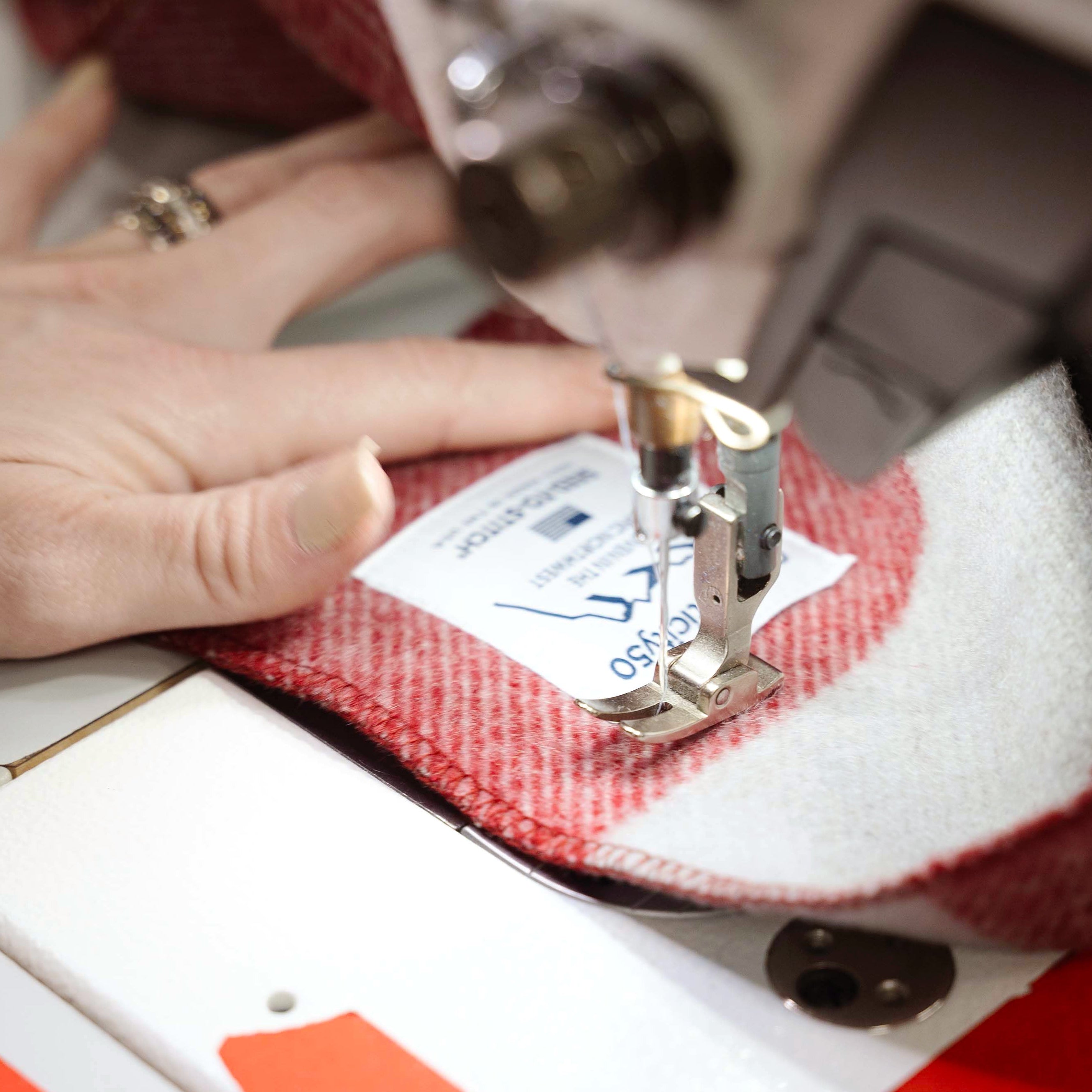 Sewing the custom tag to a Northwest Wool Throw by hand.