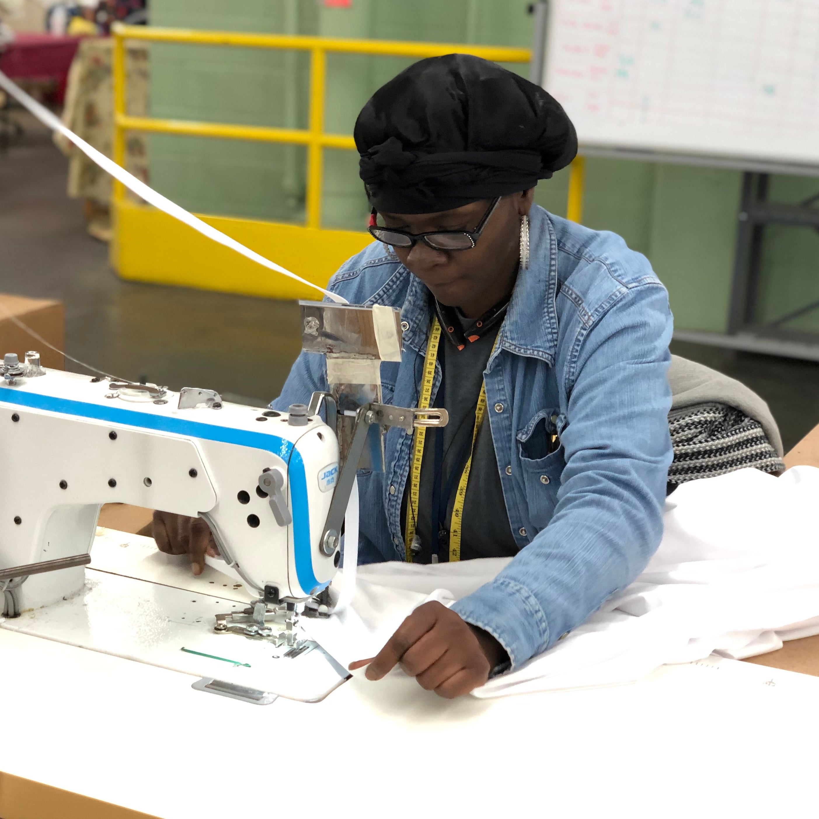 Woman sewing the final stitches on a set of Heritage American Sheets.