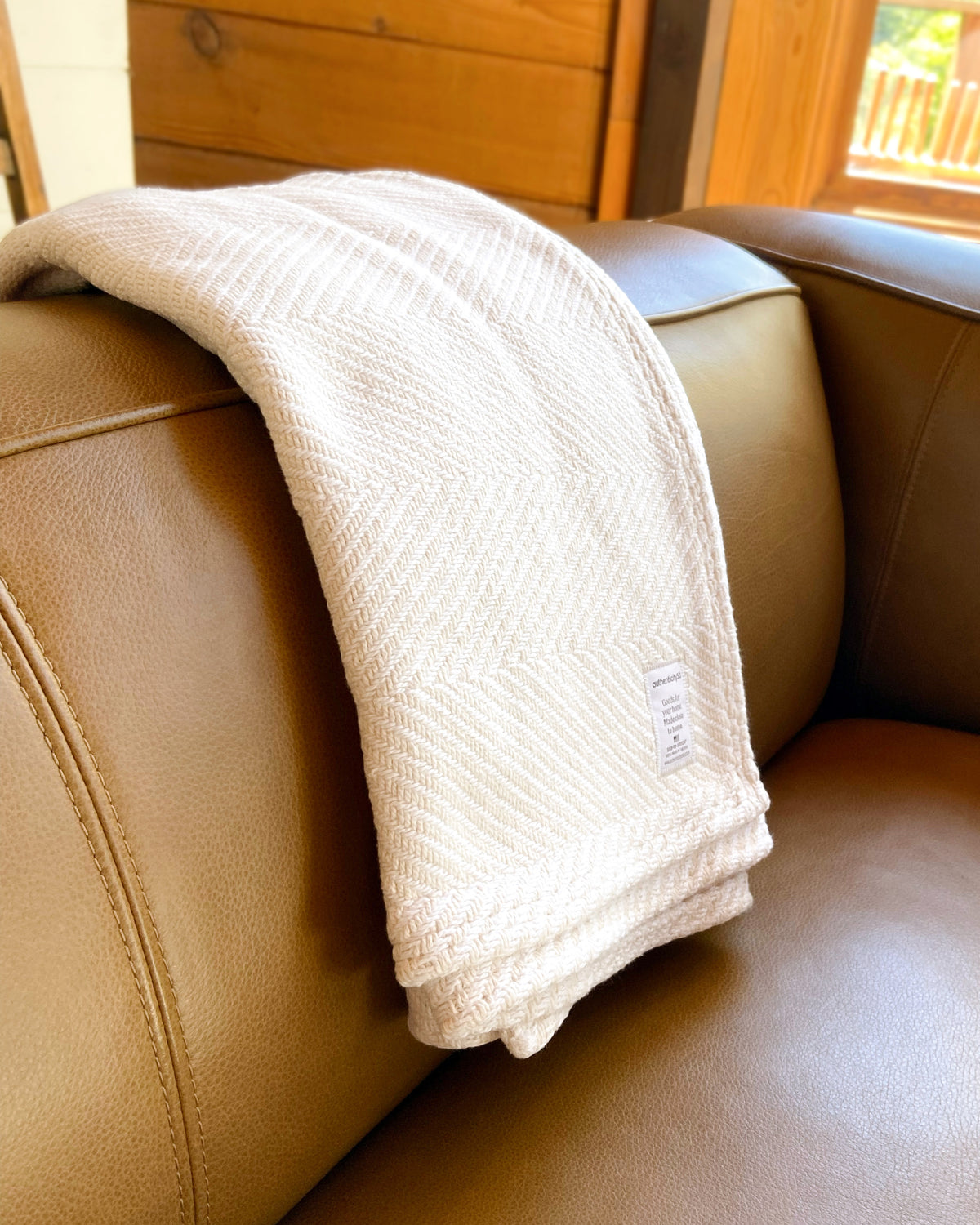Island Sand Heritage Blanket folded and draped over the back of a couch.