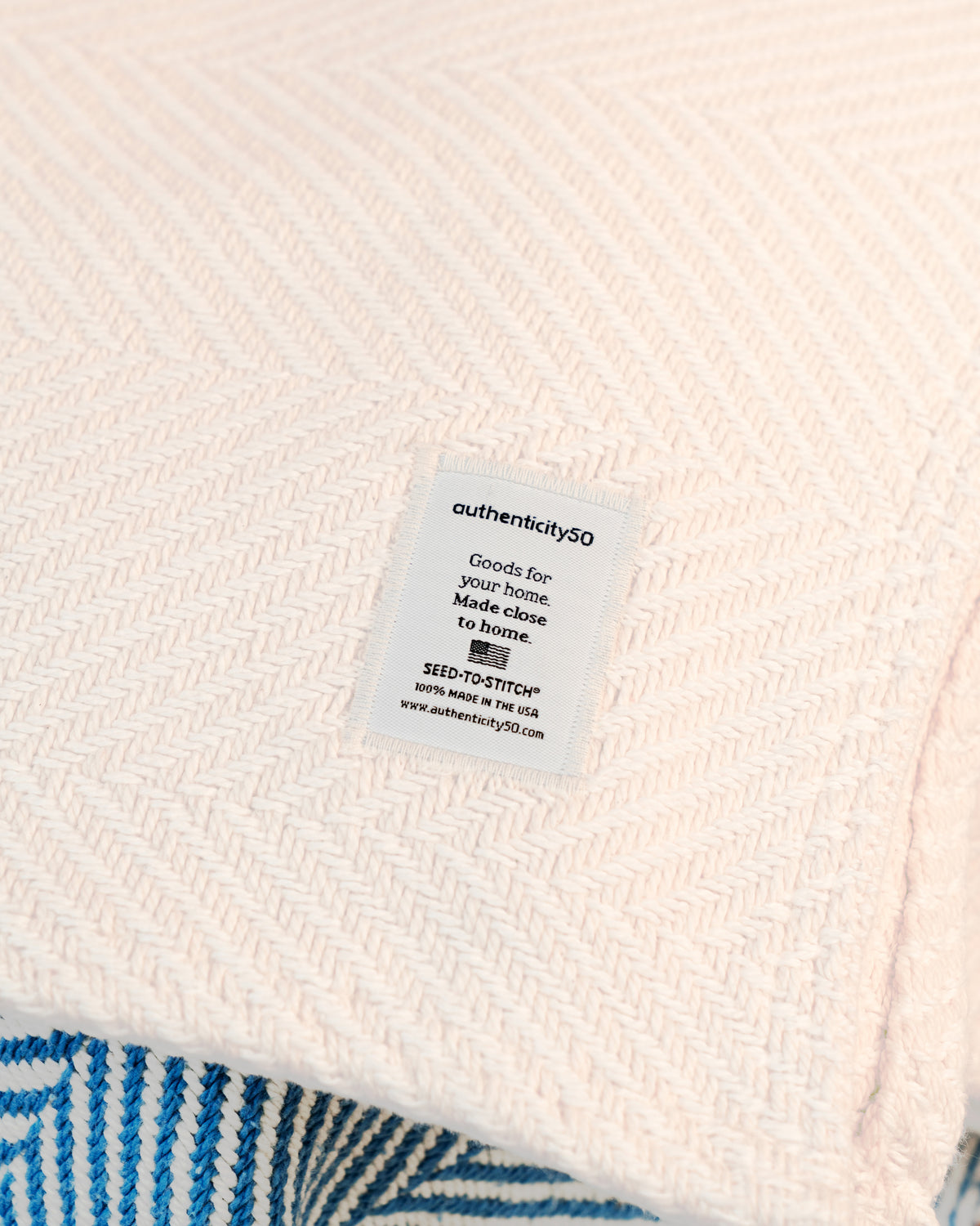 Close-up detail shot of the Island Sand Heritage Blanket's woven tag.