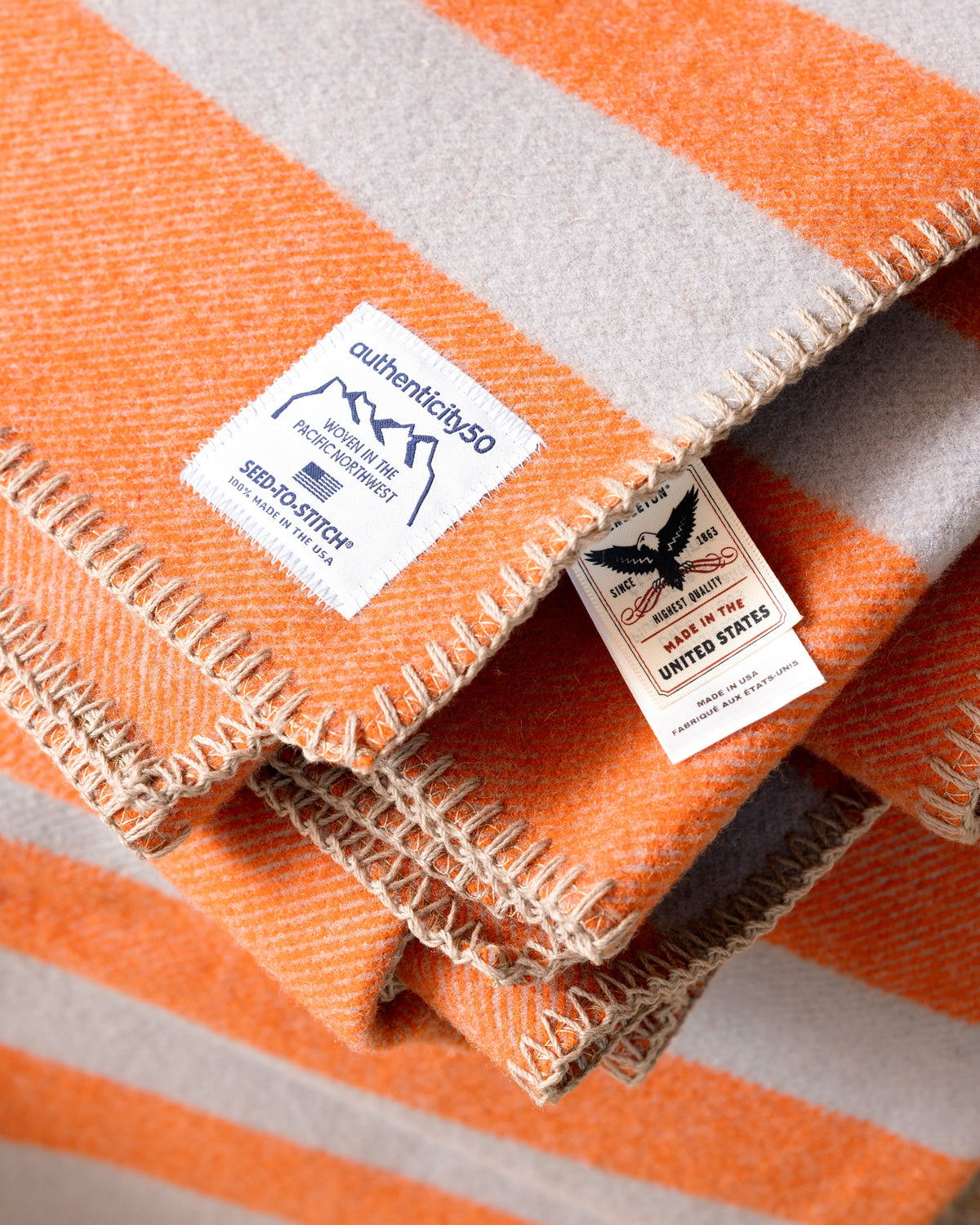 Folded stack of Mesa Sunset Northwest Wool Throws with the custom-woven Authenticity50 and Pendleton Wool Mills® Made in the United States tags front and center.
