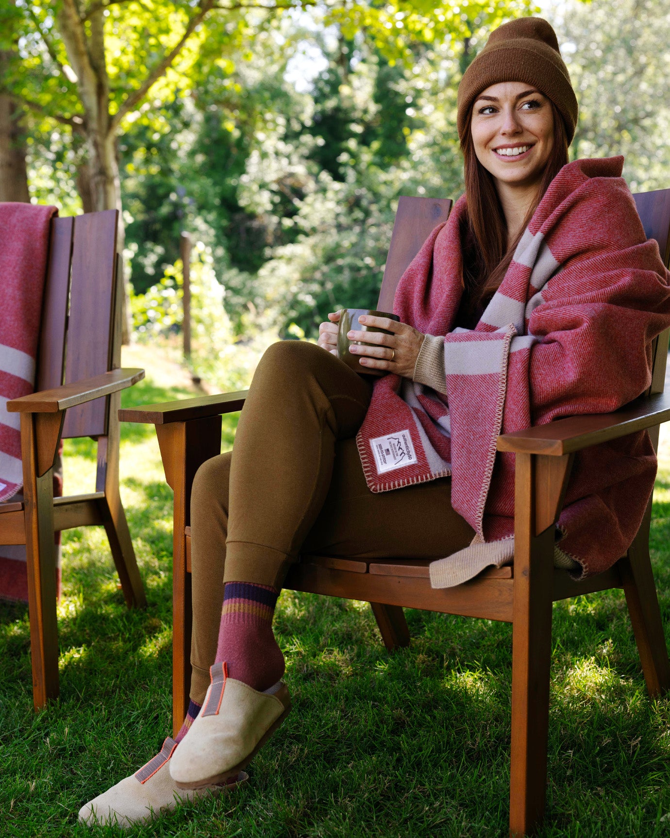 Woman relaxing in her backyard with a cup of coffee and her Northwest Wool Throws.