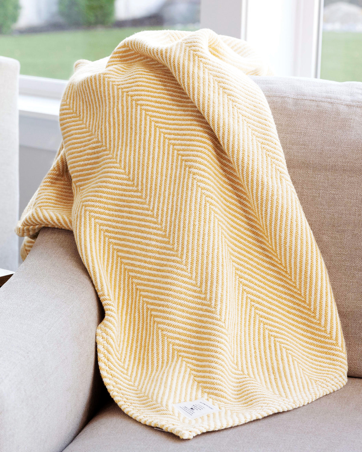 Prairie Yellow Heritage Blanket throw casually tossed on the back of a couch.