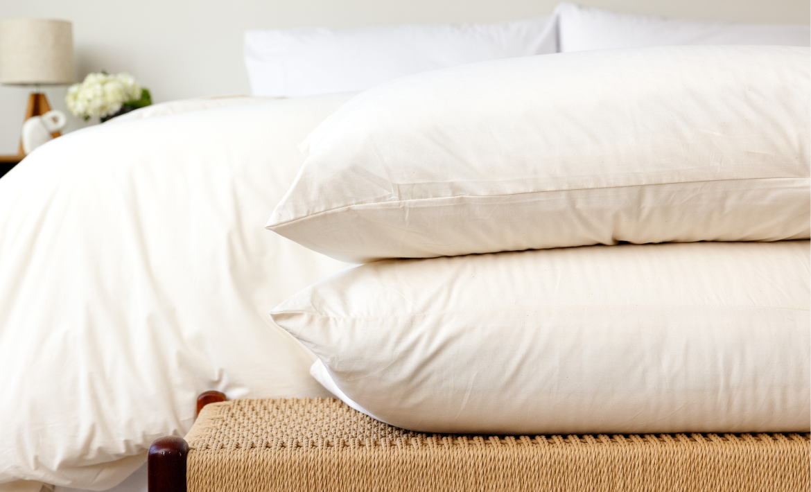Two Custom Comfort Pillows in Envelope Closure Pillowcases stacked at the foot of a bed.