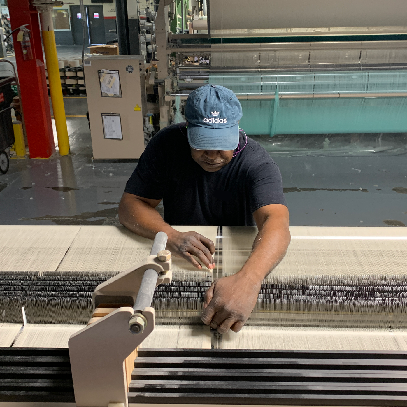 Man working on weaving looms.