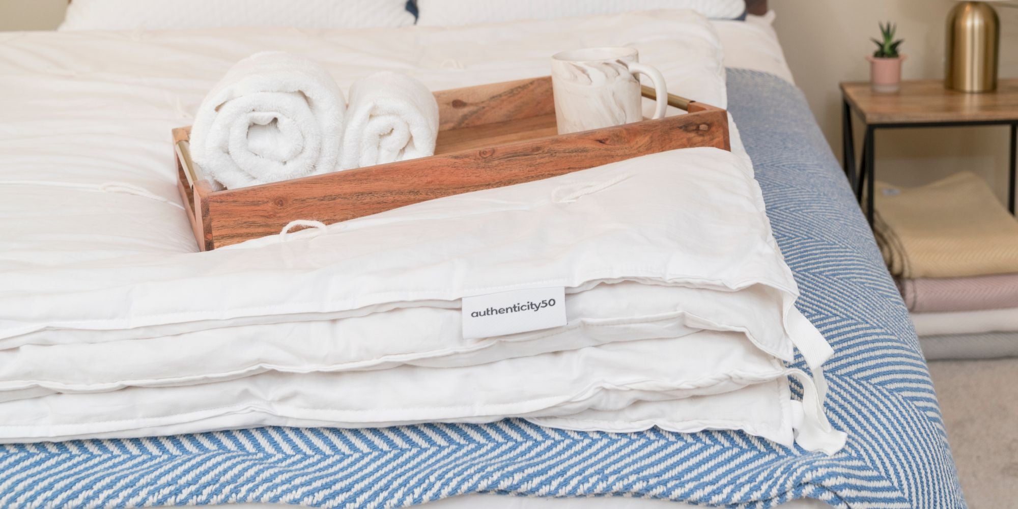 wool duvet, towels and coffee mug on a herringbone blanket