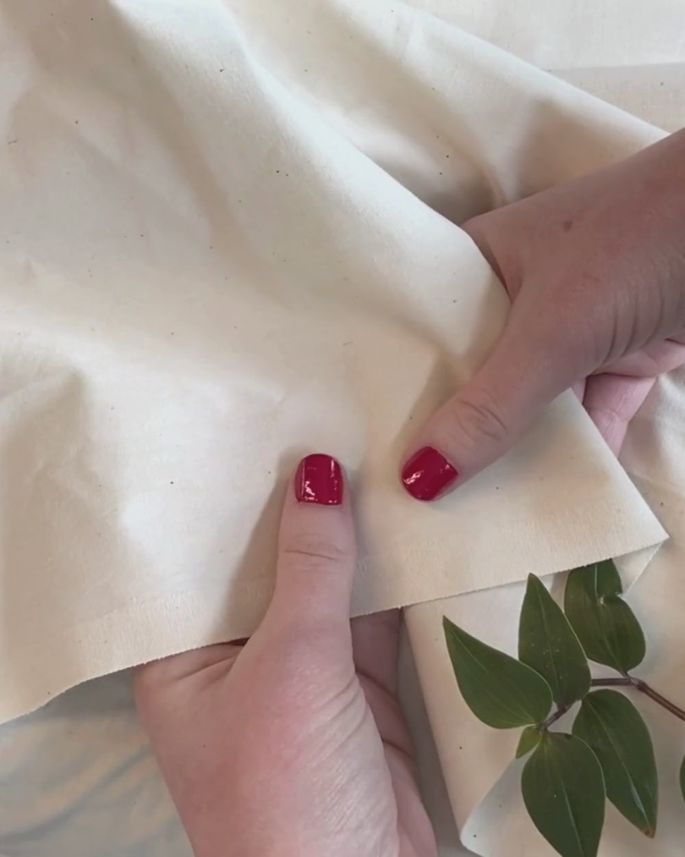 Woman glides her fingers across a set of crisp, smooth Heritage American Sheets.