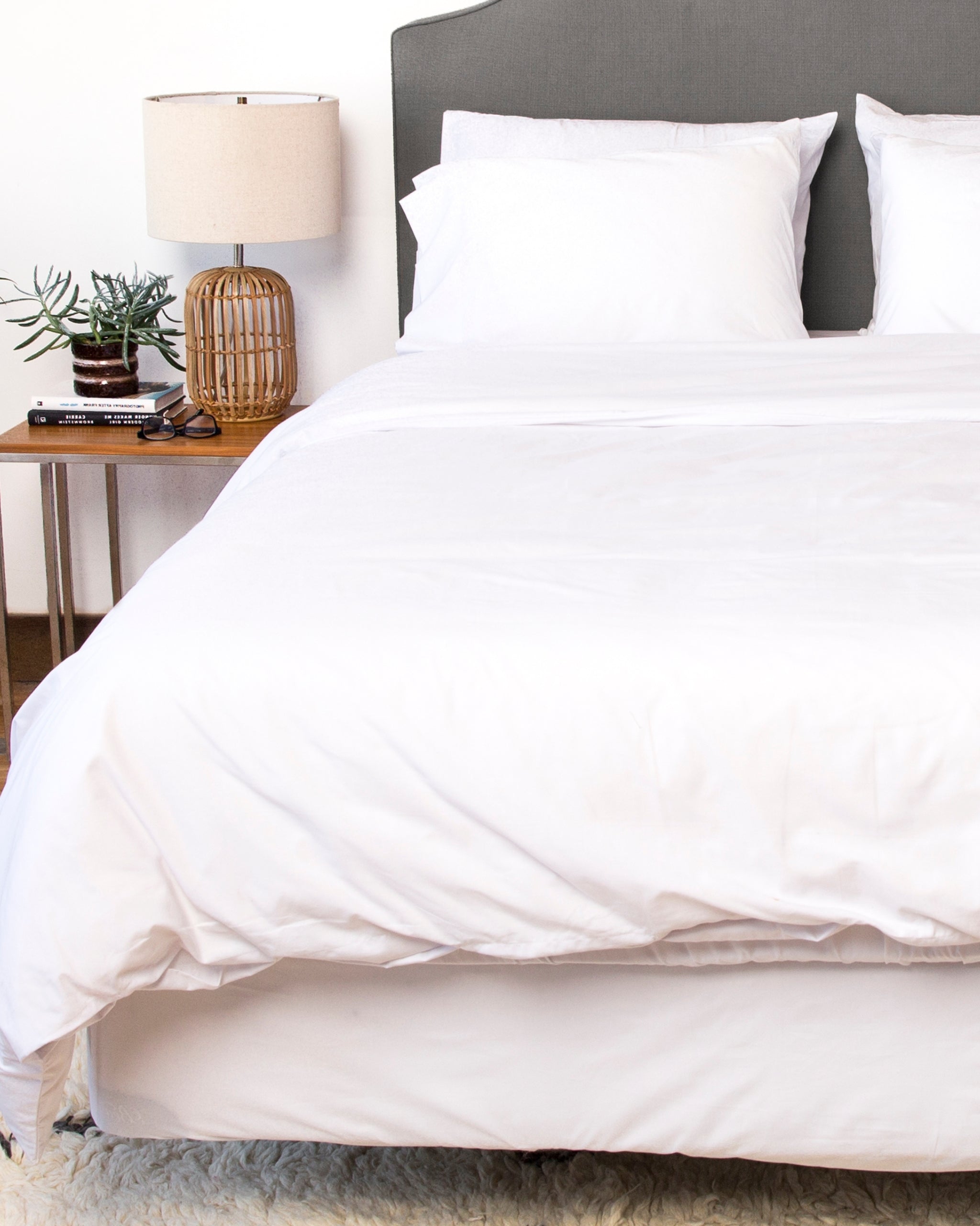 White cotton sheets and duvet cover on a bed. 
