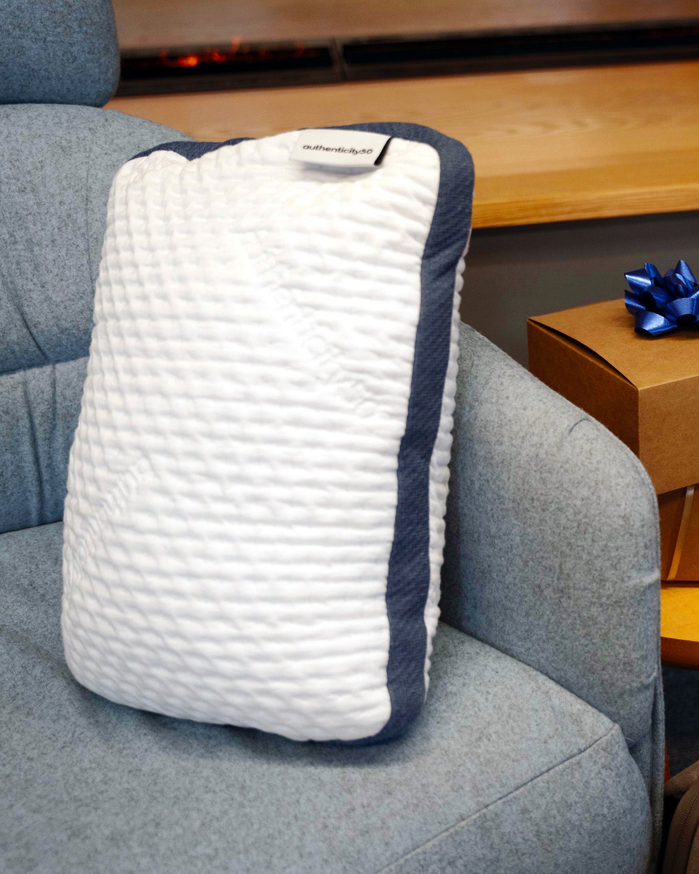 A50 Travel Pillow propped up in a chair next to a stack of wrapped gifts.