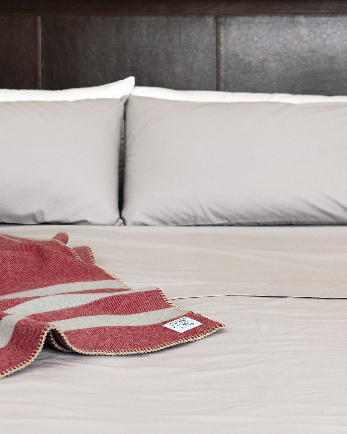 Bed made with Carolina Gray Heritage American Sheets and a Rainier Red Northwest Wool Throw.
