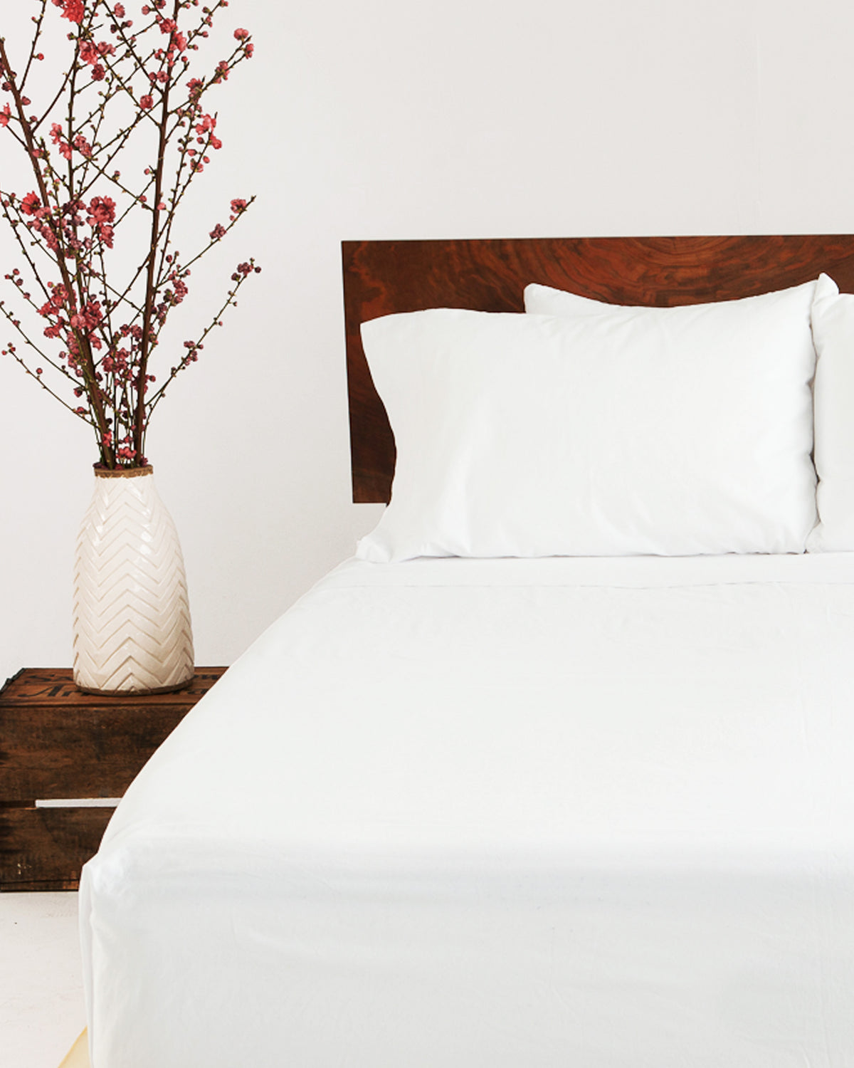 A set of Cloud White Heritage American Sheets on a bed.