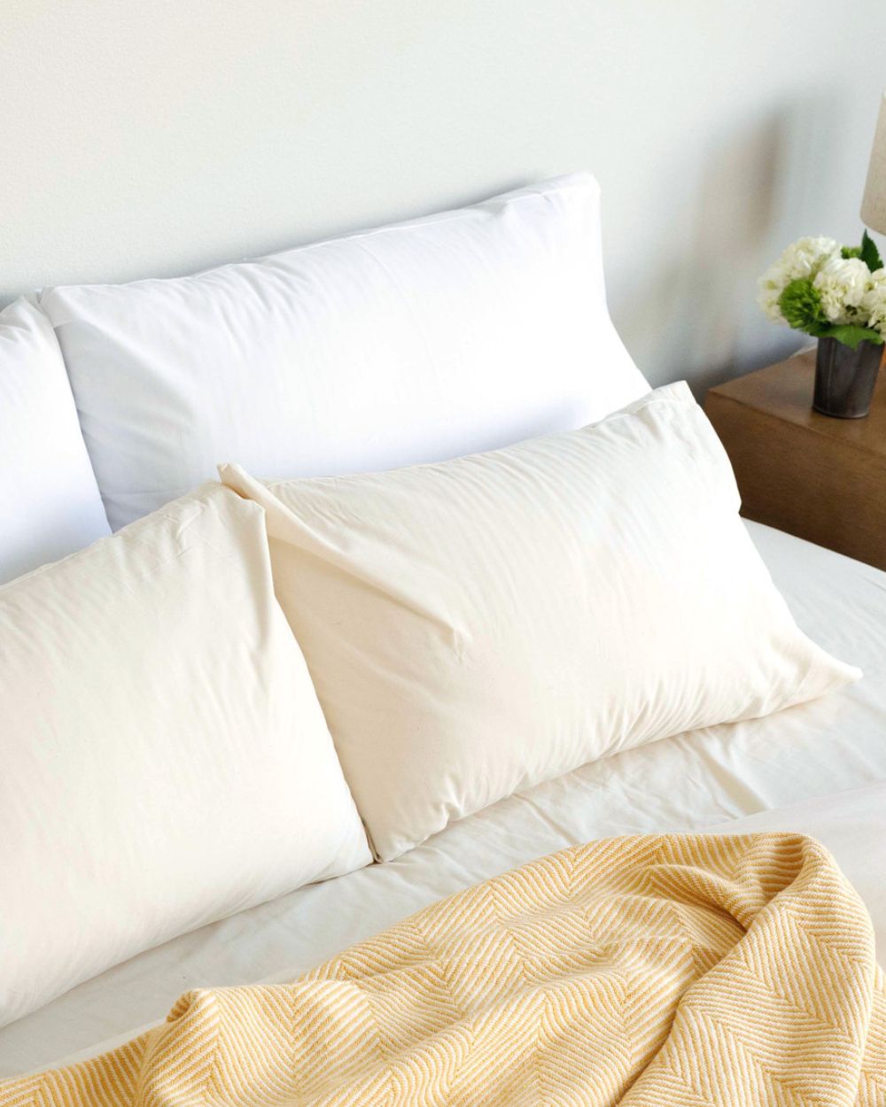 Custom Comfort Pillows, encased in Envelope Closure Pillowcases, laying on a bed with a Prairie Yellow Heritage Blanket.