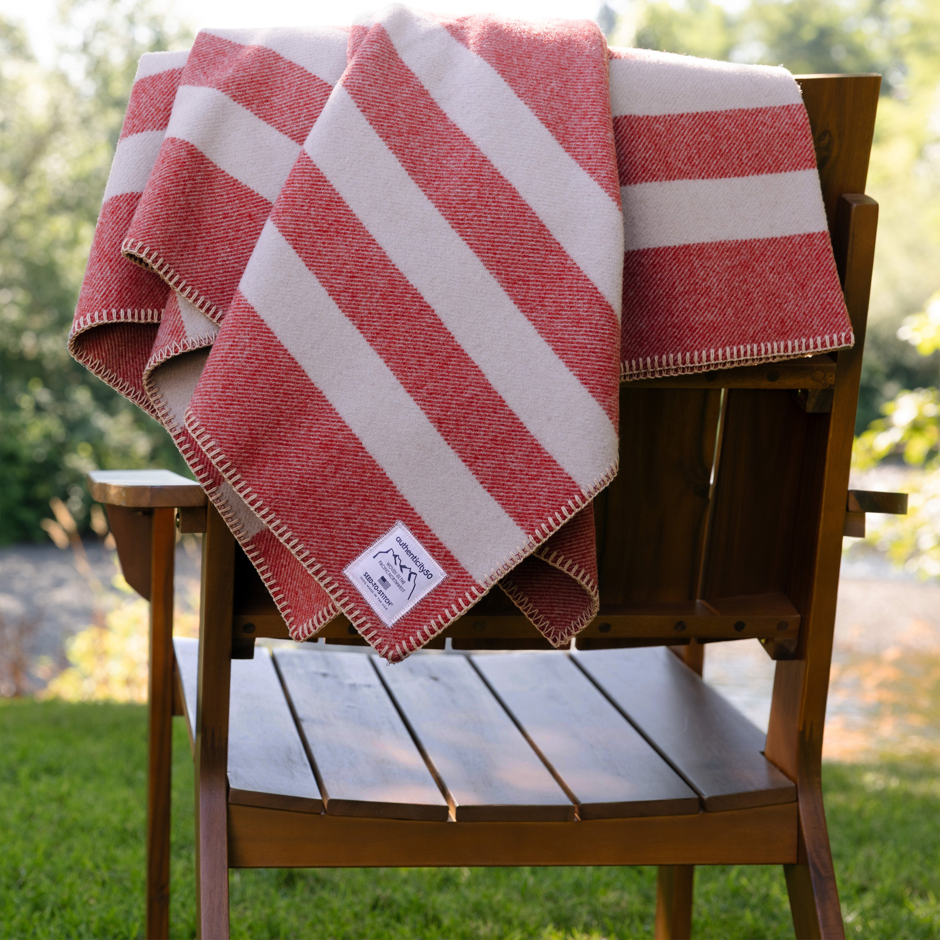 Northwest Wool Throw folded and laying on the back of a back patio chair.