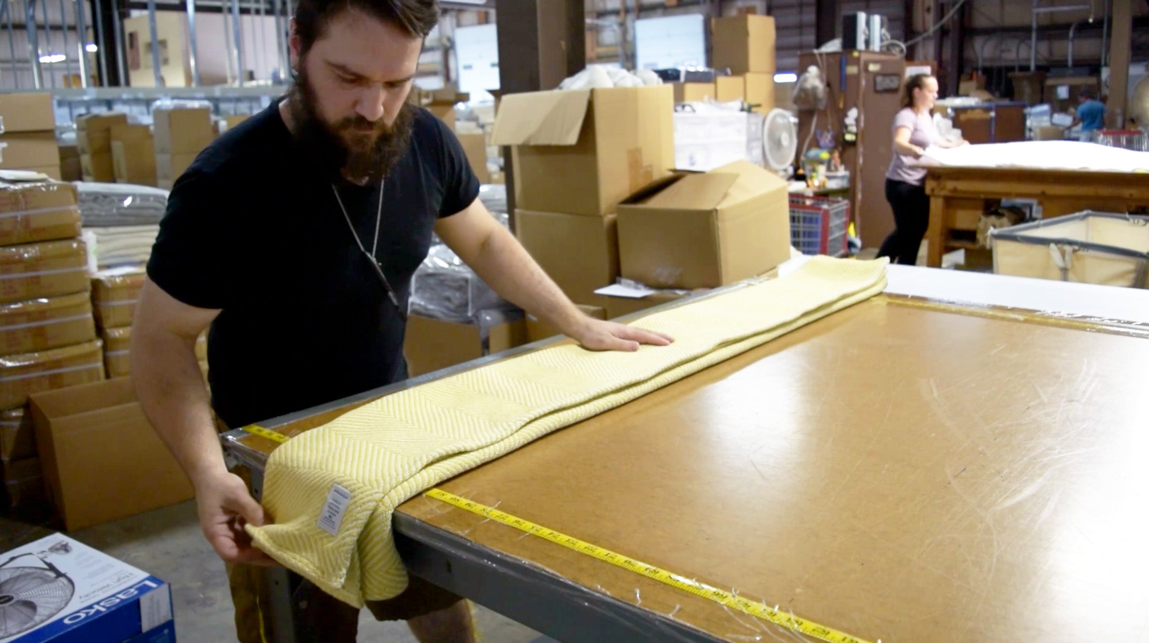Workers folding up finished Heritage Blankets before packaging them.