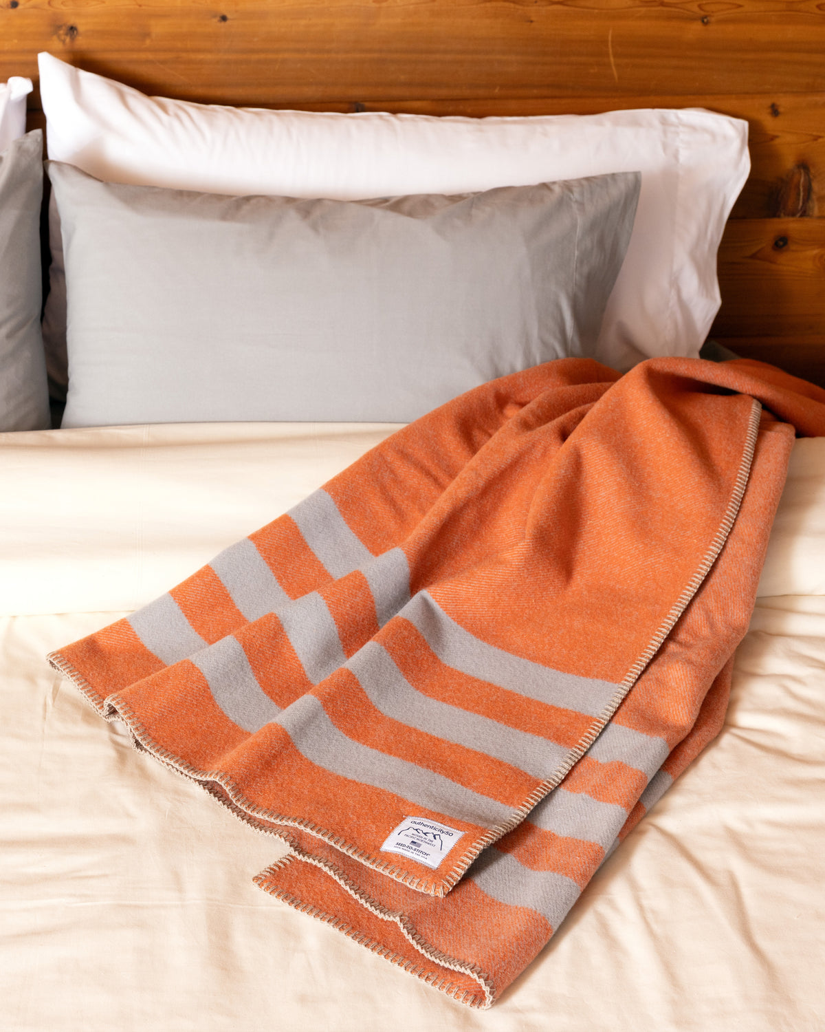 Mesa Sunset Northwest Wool Throw casually draped at the head of a bed.