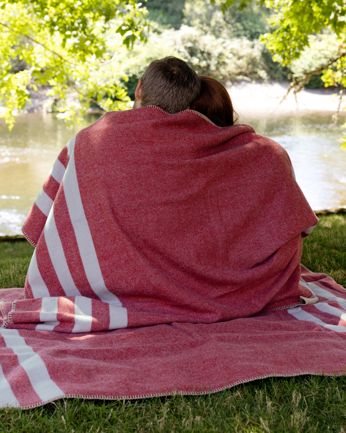 Couple relaxing in their backyard, sitting on and wrapped up in Northwest Wool Throws.
