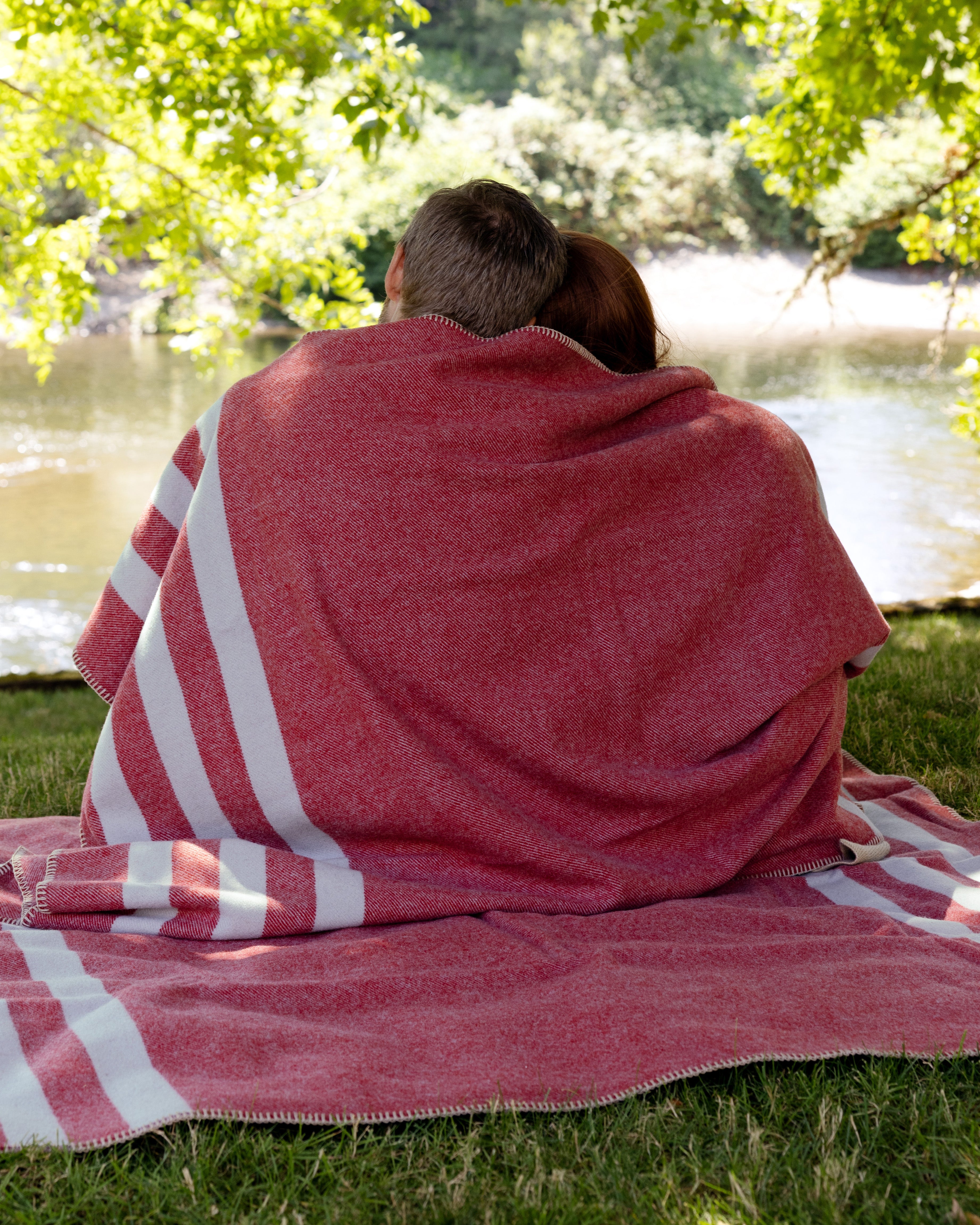 Couple relaxing in their backyard, sitting on and wrapped up in Northwest Wool Throws.