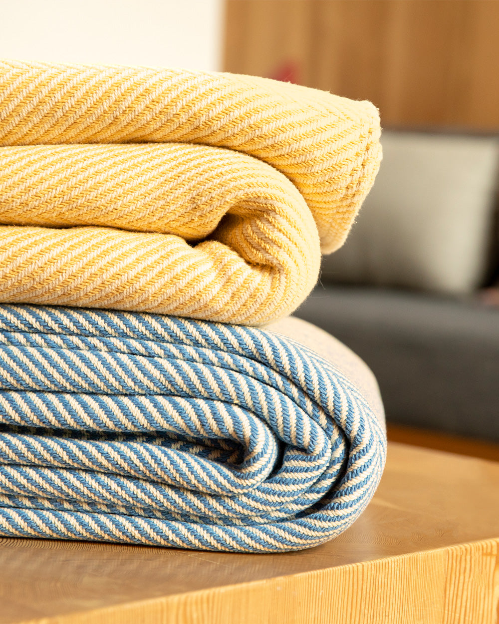 Two Heritage Blanket throws folded and stacked on a coffee table.