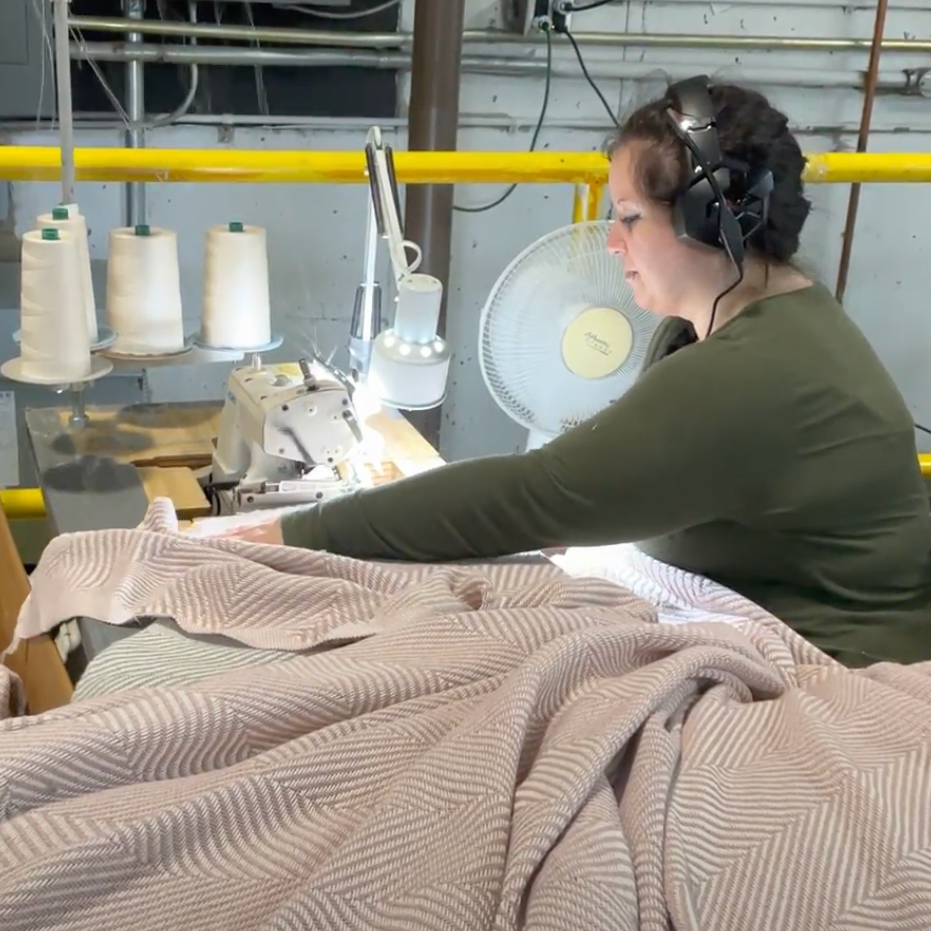 Woman putting the final hand-sewn touches on a new Heritage Blanket.
