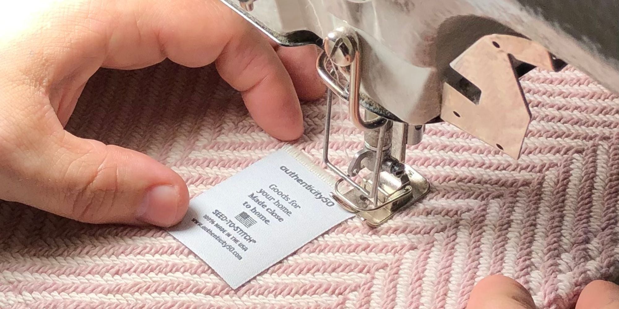 sewing a tag onto a blanket by hand