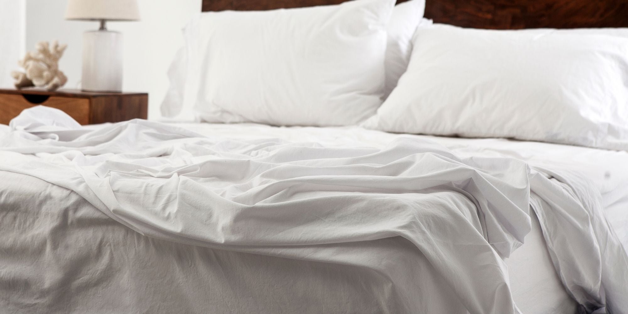 white percale cotton bed sheets on a nicely made bed