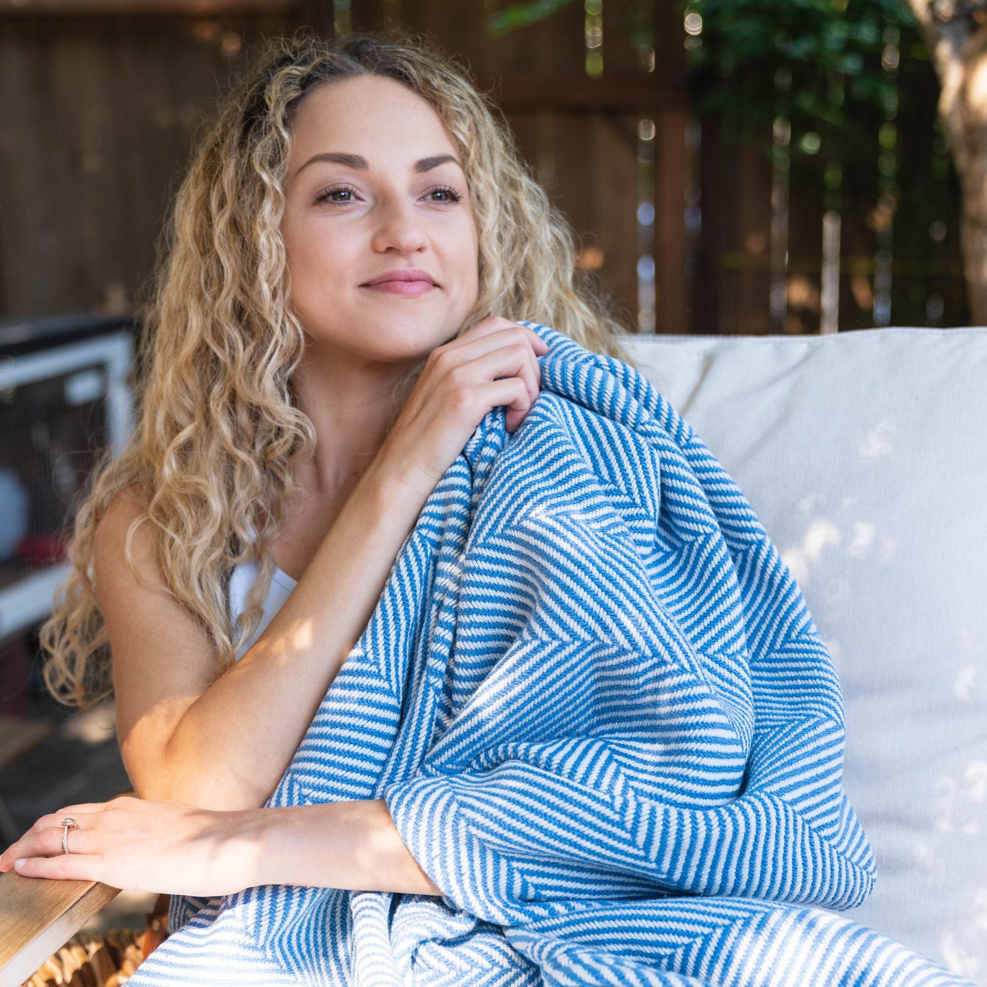 lady relaxing outside with a blue cotton blanket 