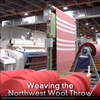 Video showing how a wool blanket is woven in America in washington state. It includes footage of sheep, yarn spinning and weaving. 