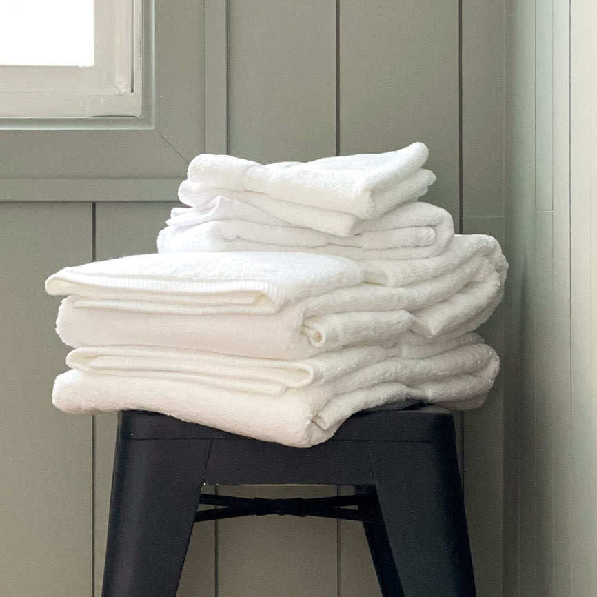 cotton towels stacked on bath stool